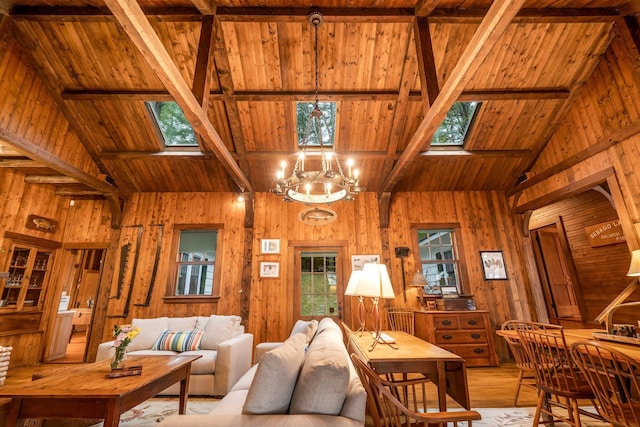 137 Birch Ln, Belgrade, ME 04917 - living area with a skylight, wood ceiling with exposed beams, high vaulted ceiling, wood walls, and light wood-style floors