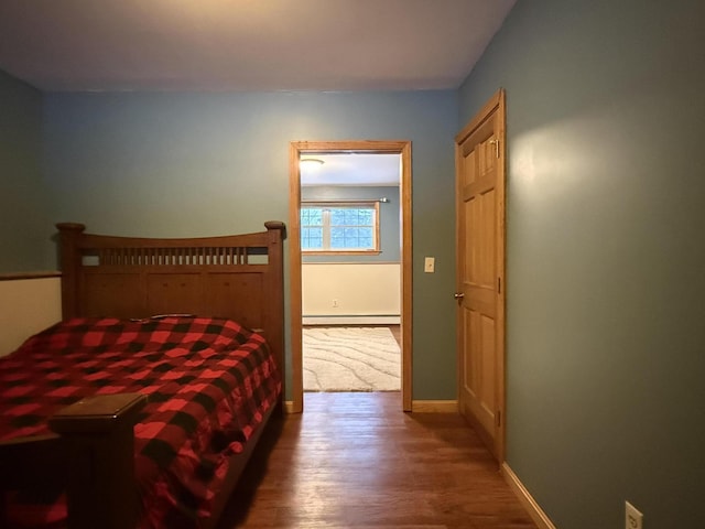 bedroom with wood-type flooring and a baseboard radiator