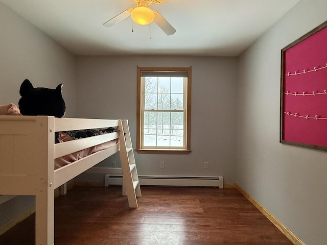 bedroom with hardwood / wood-style flooring, ceiling fan, and a baseboard heating unit