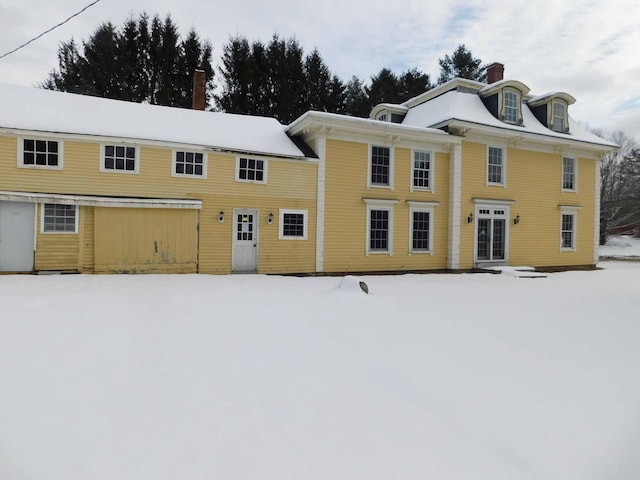 view of snow covered back of property