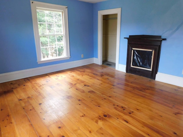 unfurnished living room with light wood-type flooring and a fireplace