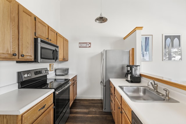 kitchen with appliances with stainless steel finishes, dark hardwood / wood-style flooring, hanging light fixtures, and sink