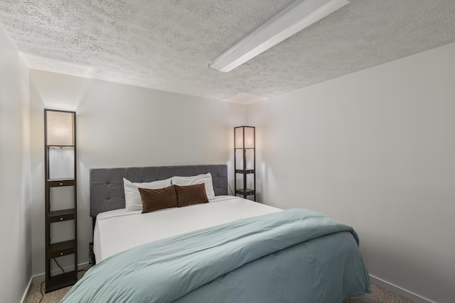 bedroom featuring carpet flooring and a textured ceiling