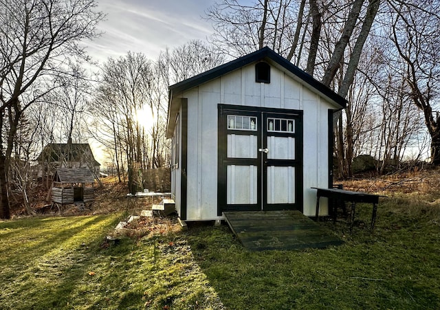 outdoor structure at dusk featuring a yard