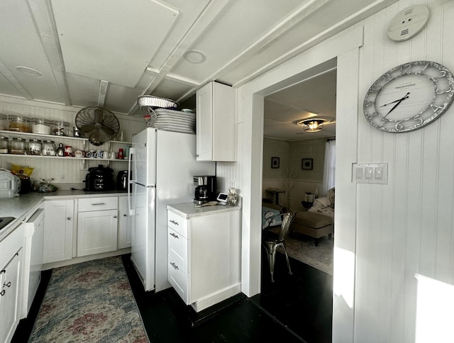 kitchen featuring wood walls, white cabinets, and white appliances