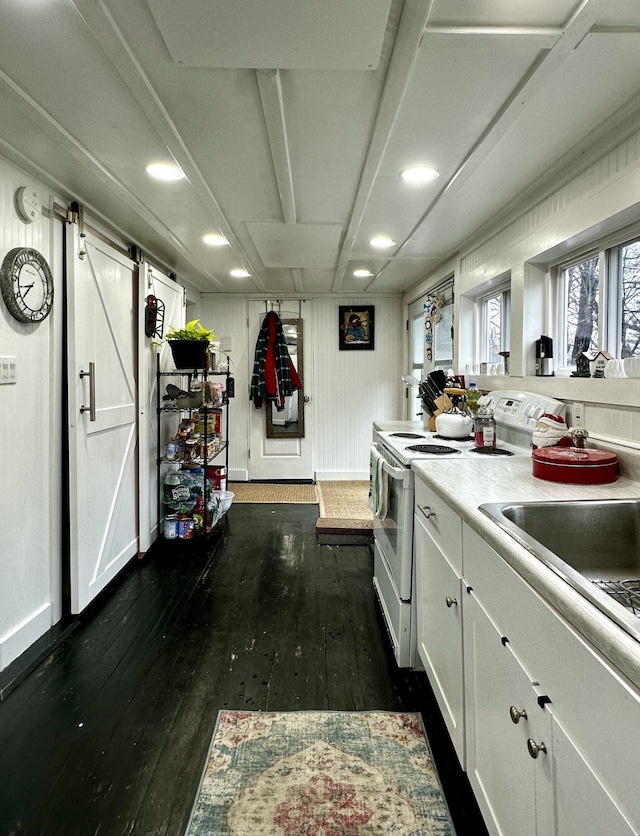 kitchen with a barn door, white cabinetry, dark wood-type flooring, and white electric range oven