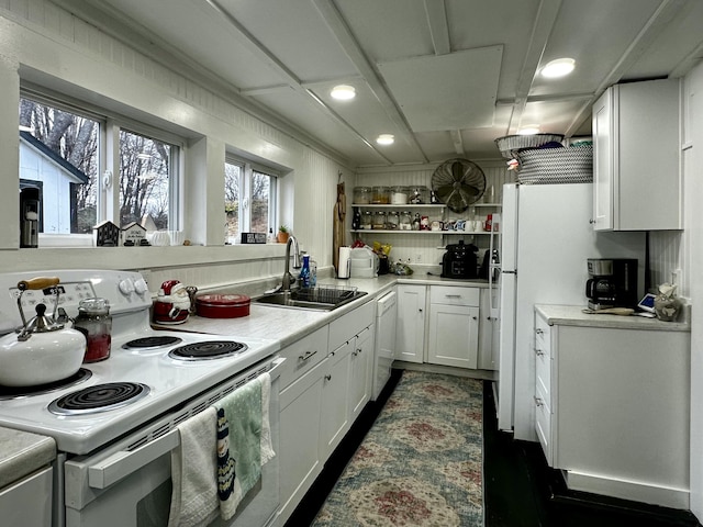 kitchen featuring white cabinetry, sink, and white appliances