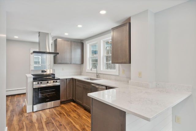 kitchen with kitchen peninsula, dark hardwood / wood-style flooring, island range hood, sink, and stainless steel stove