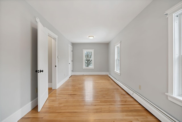 spare room featuring a baseboard radiator and light hardwood / wood-style flooring