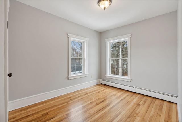 unfurnished room with light wood-type flooring and a baseboard radiator