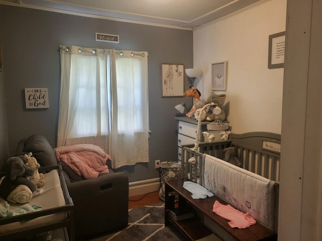 bedroom featuring a nursery area and crown molding