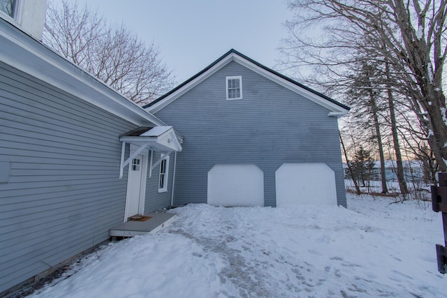 snow covered property featuring a garage