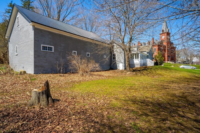 10 Nokomis Rd, Corinna, ME 04928 - view of property exterior featuring a yard and metal roof
