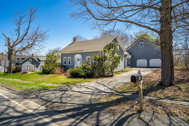 10 Nokomis Rd, Corinna, ME 04928 - view of front of house with a garage, a chimney, driveway, and a front lawn