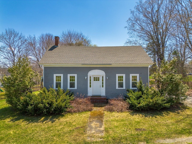 10 Nokomis Rd, Corinna, ME 04928 - view of front of home with a shingled roof, a chimney, and a front yard