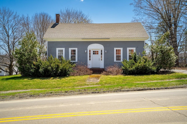 10 Nokomis Rd, Corinna, ME 04928 - view of front of house with a shingled roof, a chimney, and a front yard