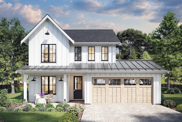 modern farmhouse featuring a garage, covered porch, and a front lawn