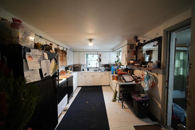 kitchen with sink, white cabinets, and black appliances