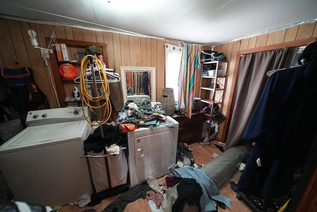 laundry area featuring wooden walls, light hardwood / wood-style flooring, and washer / dryer