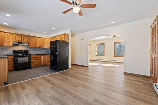 kitchen with a baseboard heating unit, light hardwood / wood-style flooring, backsplash, and black appliances