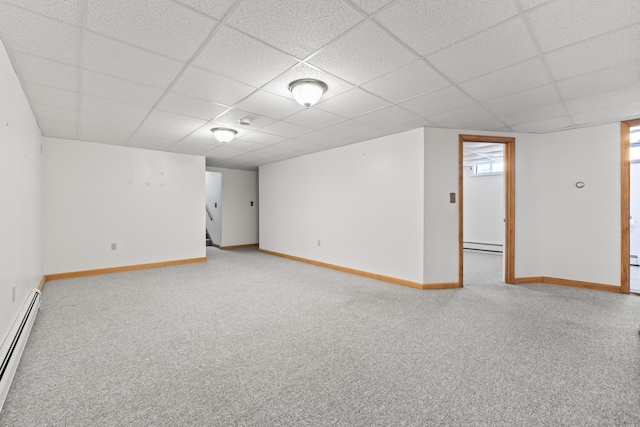 spare room with a paneled ceiling, light carpet, and baseboard heating