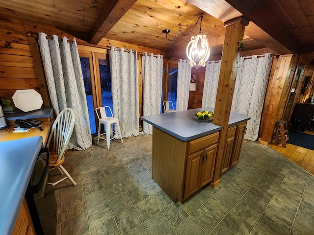 interior space featuring wooden ceiling, a notable chandelier, a center island, hanging light fixtures, and wood walls