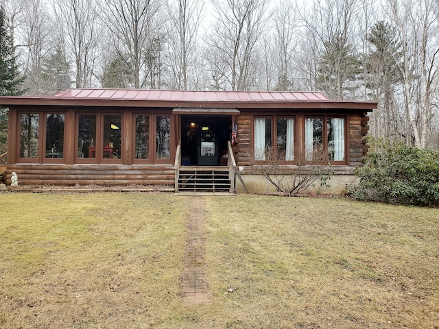 log home with a sunroom and a front yard