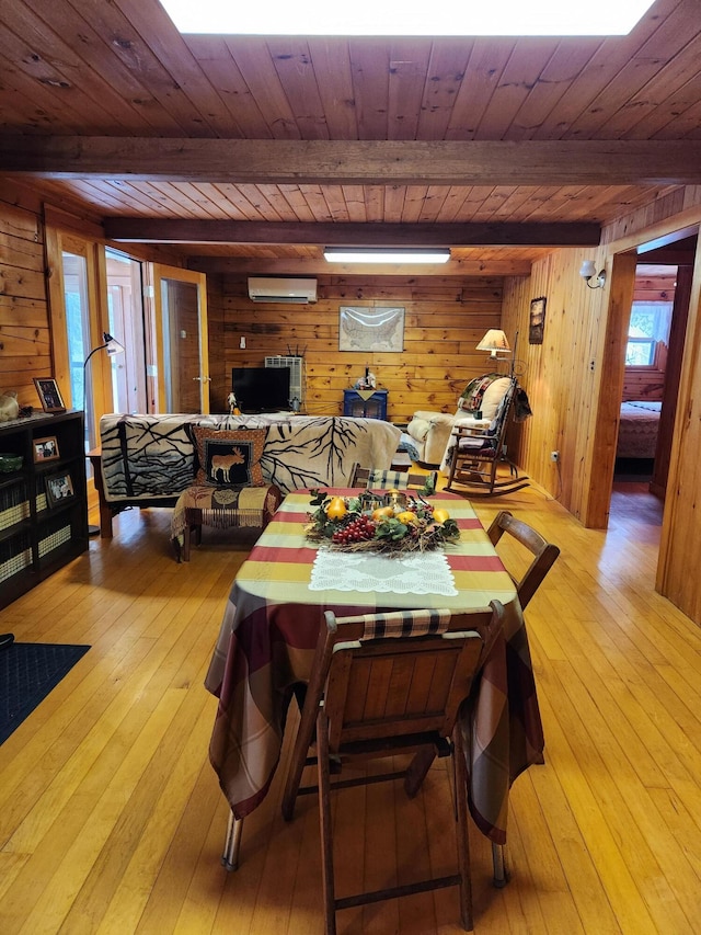 dining room with wood walls, light wood-type flooring, and a wall mounted AC