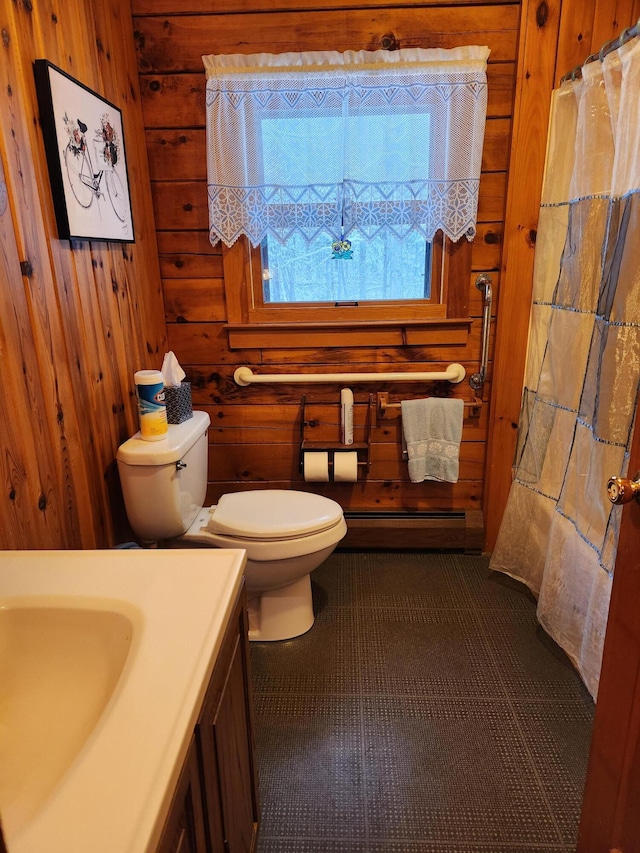 bathroom featuring a baseboard radiator, tile patterned flooring, wood walls, toilet, and vanity