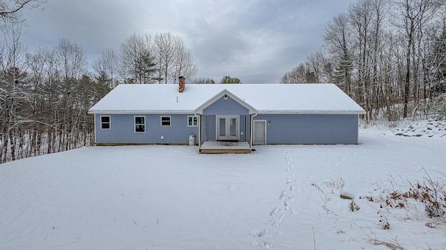 snow covered property with french doors and a wooden deck