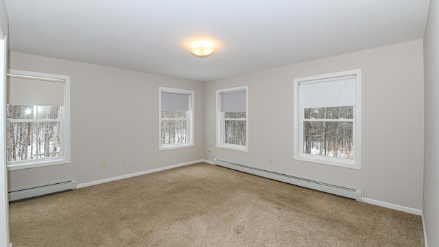 carpeted spare room with a baseboard heating unit