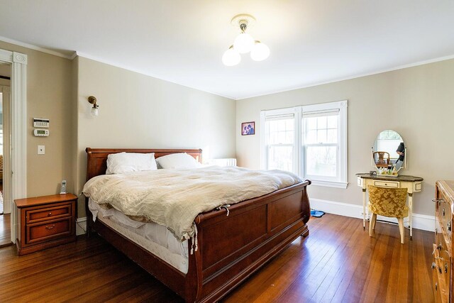 bedroom with crown molding and dark hardwood / wood-style floors