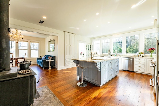 kitchen featuring a center island with sink, a wealth of natural light, white cabinetry, and appliances with stainless steel finishes