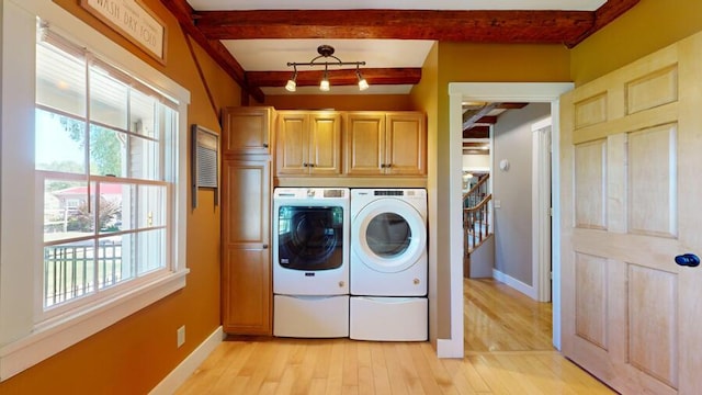 washroom featuring light hardwood / wood-style flooring, cabinets, and independent washer and dryer