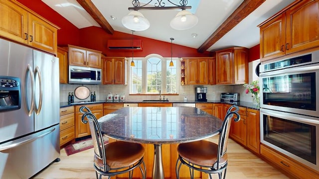 kitchen with backsplash, hanging light fixtures, a kitchen island, and stainless steel appliances