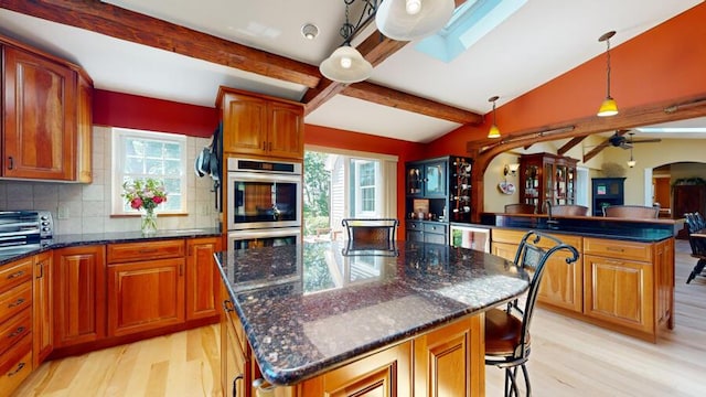 kitchen featuring a kitchen island, a healthy amount of sunlight, and hanging light fixtures