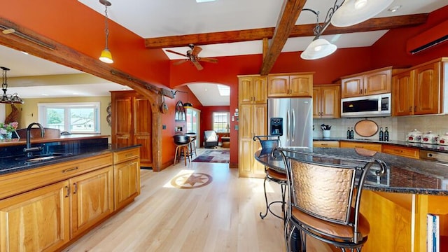 kitchen featuring pendant lighting, stainless steel appliances, light hardwood / wood-style flooring, and ceiling fan