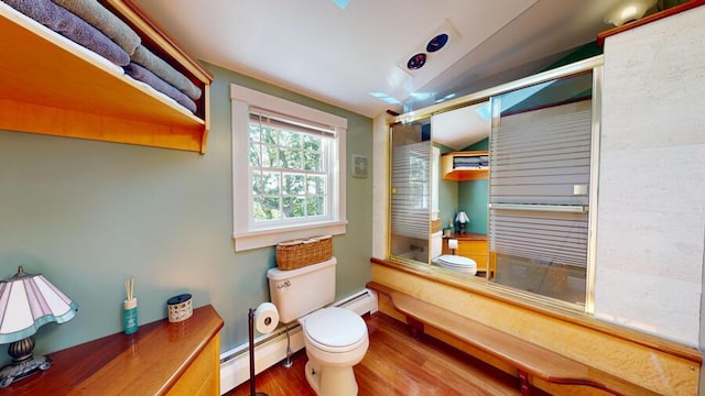 bathroom featuring combined bath / shower with glass door, vaulted ceiling, hardwood / wood-style flooring, a baseboard radiator, and toilet