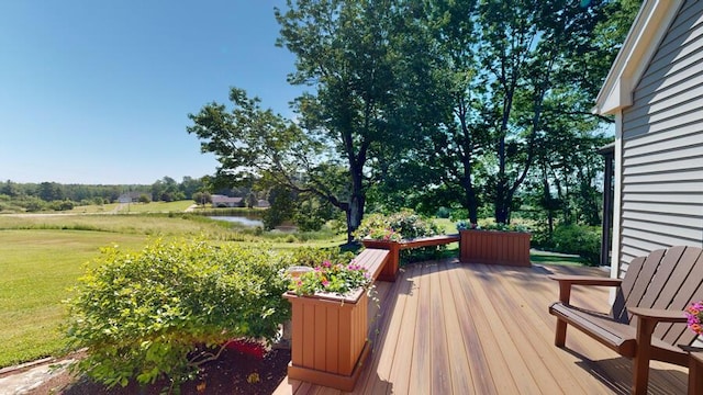 wooden terrace with a yard and a water view