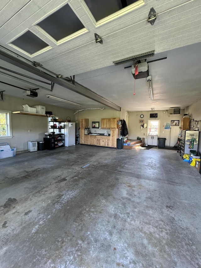 garage featuring white refrigerator and a garage door opener