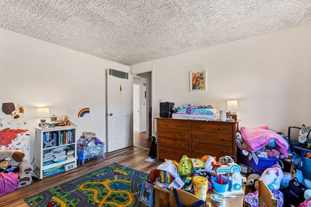 bedroom with a textured ceiling and hardwood / wood-style flooring