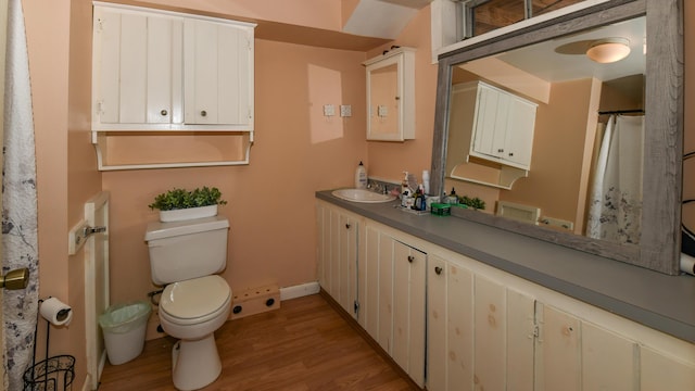 bathroom with toilet, vanity, and hardwood / wood-style flooring