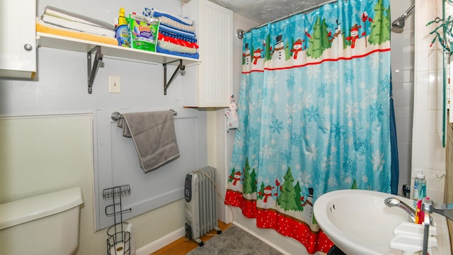 bathroom featuring radiator, hardwood / wood-style flooring, sink, and toilet