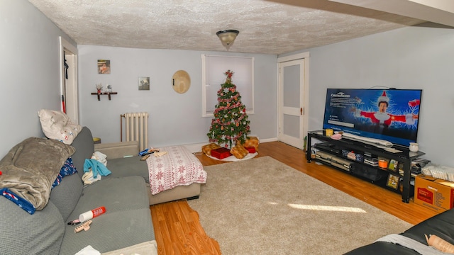 living room with radiator, a textured ceiling, and hardwood / wood-style flooring