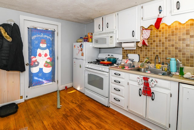 kitchen featuring white appliances, dark hardwood / wood-style floors, white cabinetry, and sink