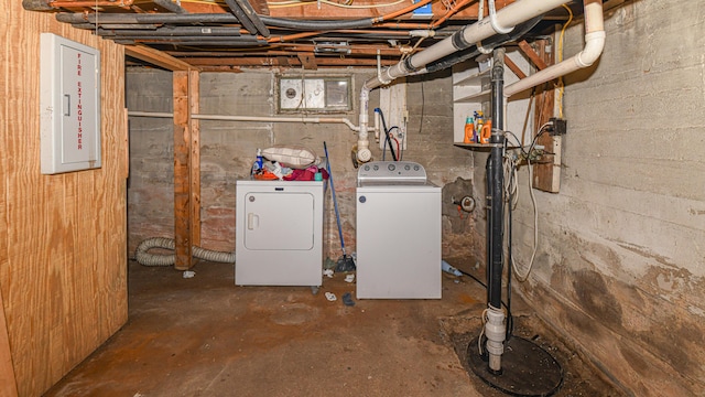 basement featuring electric panel and washing machine and clothes dryer