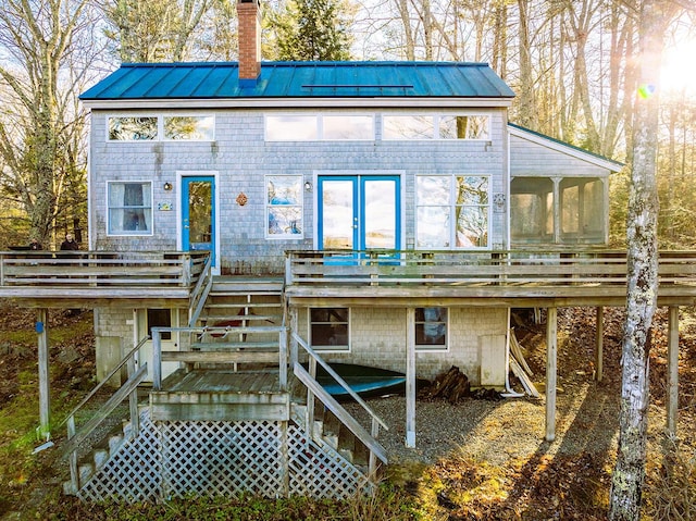 rear view of property with a deck and a sunroom