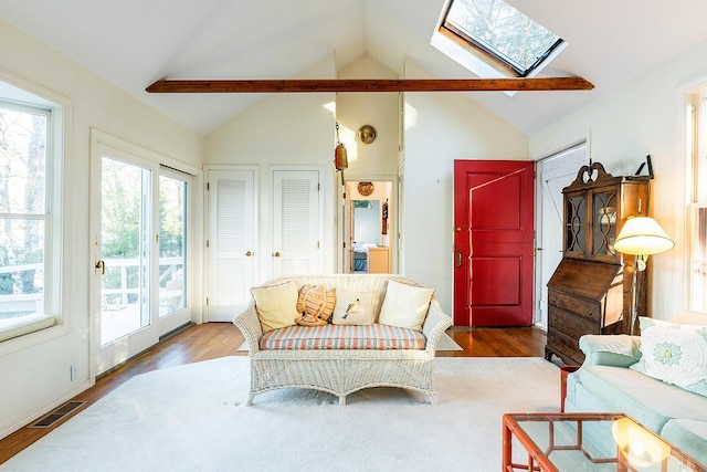 living room with lofted ceiling with skylight and hardwood / wood-style flooring