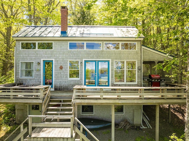 161 Beaucaire Ave, Camden, ME 04843 - rear view of property featuring a standing seam roof, stairway, a wooden deck, a chimney, and metal roof