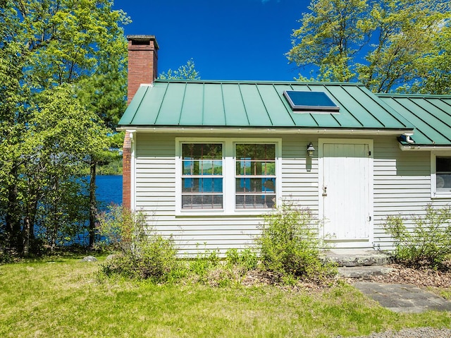 161 Beaucaire Ave, Camden, ME 04843 - view of front facade with a standing seam roof, a chimney, and metal roof